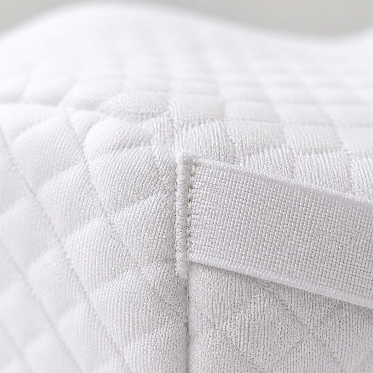Close-up of the white AlignaFit knee pillow quilted knit fabric and strap stitching