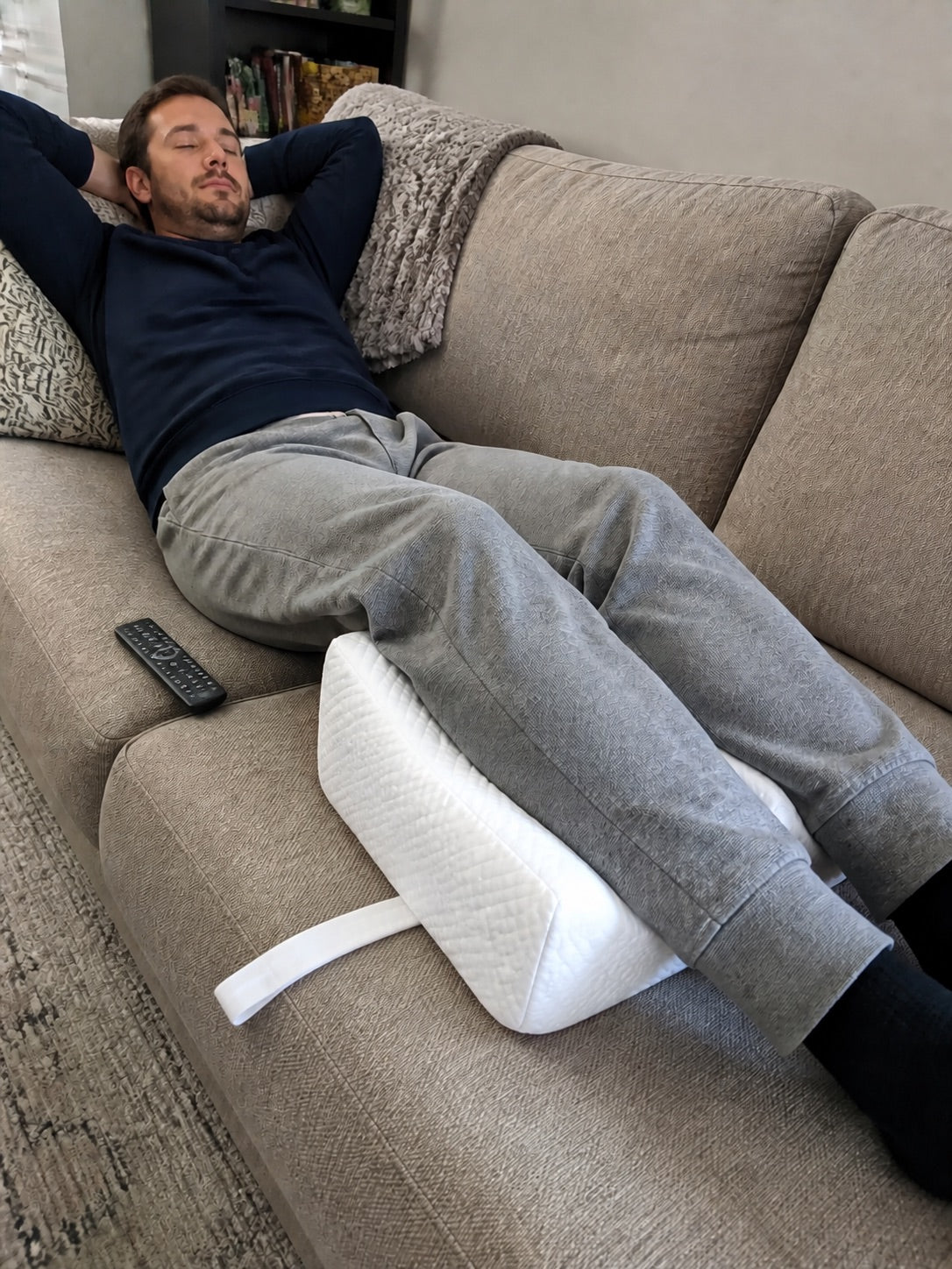 Lying on the back with the AlignaFit knee pillow under the knees