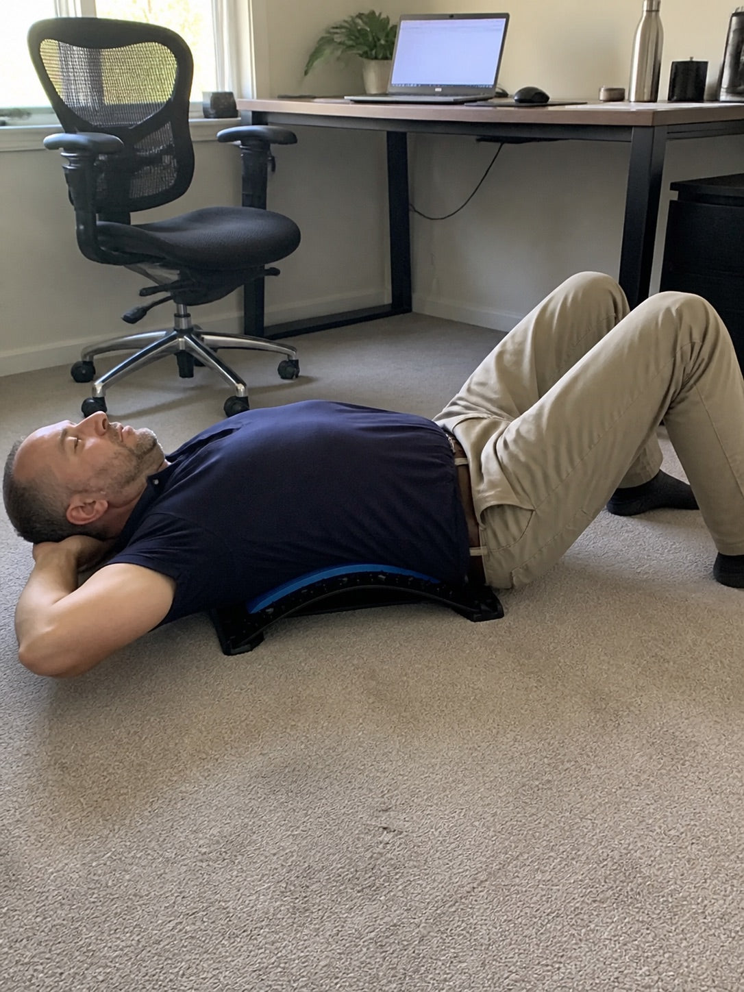 Using the AlignaFit back stretcher beside a home office desk