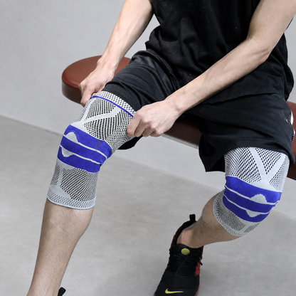 Man seated wearing the AlignaFit knee compression sleeve on both knees