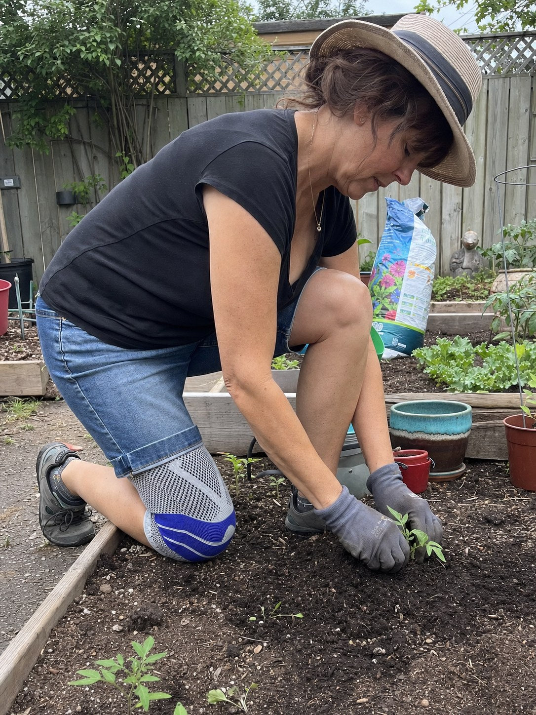 Kneeling in the garden wearing the AlignaFit knee sleeve