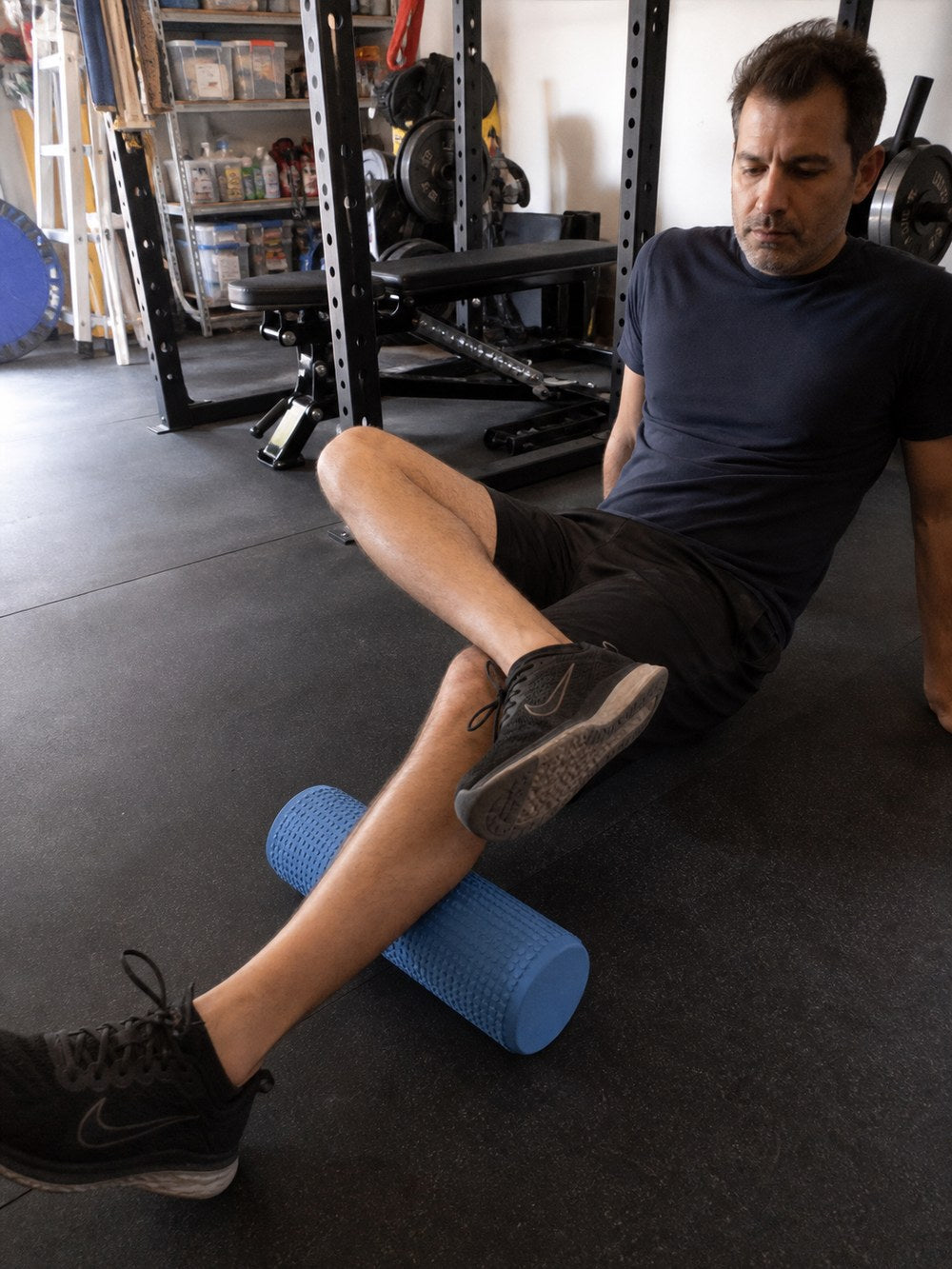 Rolling the calves with the AlignaFit foam roller in a home gym
